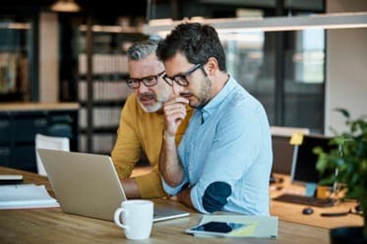 2 businessmen looking at laptop thinking about insurance concerns of business